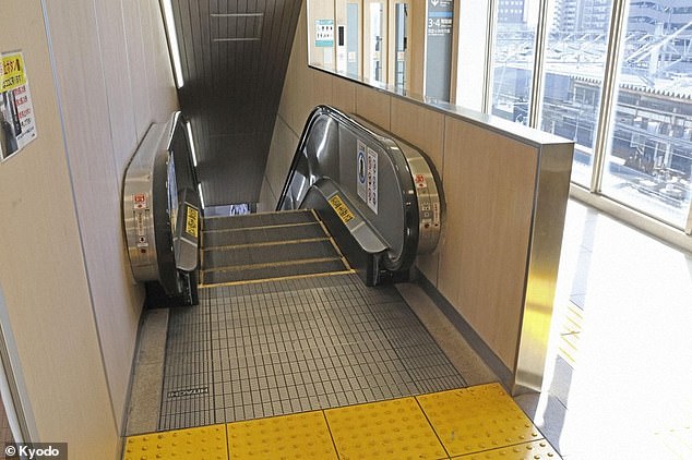 The man from Hitachi, a city in Ibaraki Prefecture, was alert when he was found around 9pm on Tuesday near the escalator exit (pictured), but later lost consciousness and was taken to a local hospital, local media report.