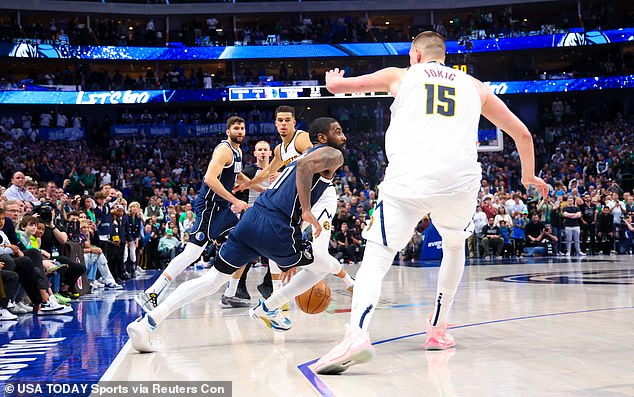 Dallas Mavericks guard Kyrie Irving (11) dribbles past Denver Nuggets center Nikola Jokic