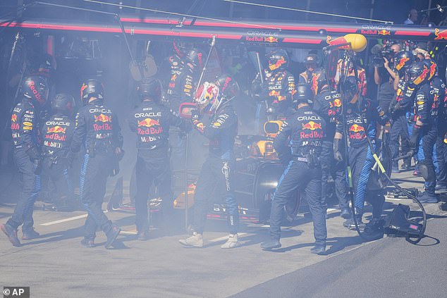 Verstappen (center) is seen exiting his Red Bull after the pit crew battled flames coming from the right rear brake.