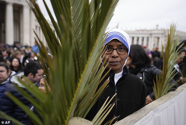 Worshipers hold palm branches before the start of Palm Sunday mass in St. Peter's Square at the Vatican
