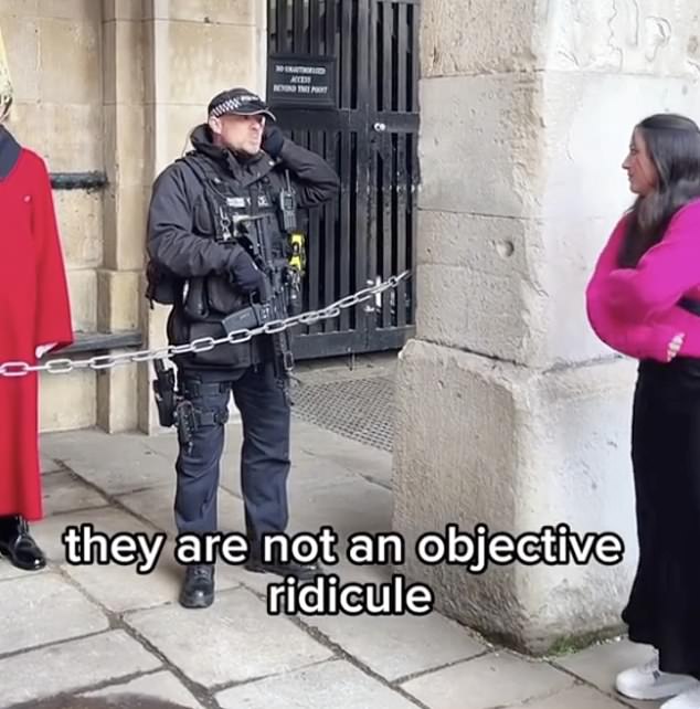 An officer enters to discuss the matter with the guard before warning the group to stop
