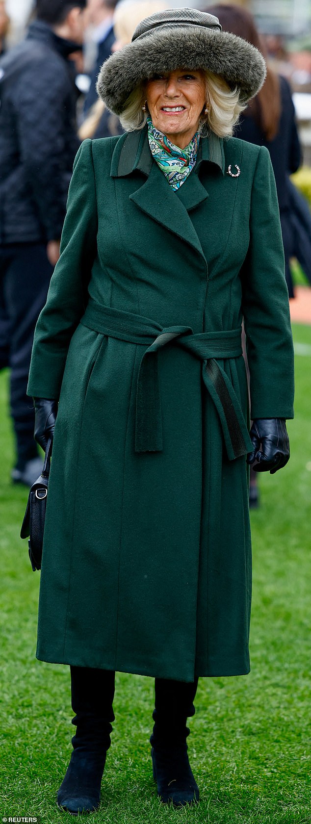 Camilla donned a structured green coat and furry gray hat to ward off the gloomy weather at the event today
