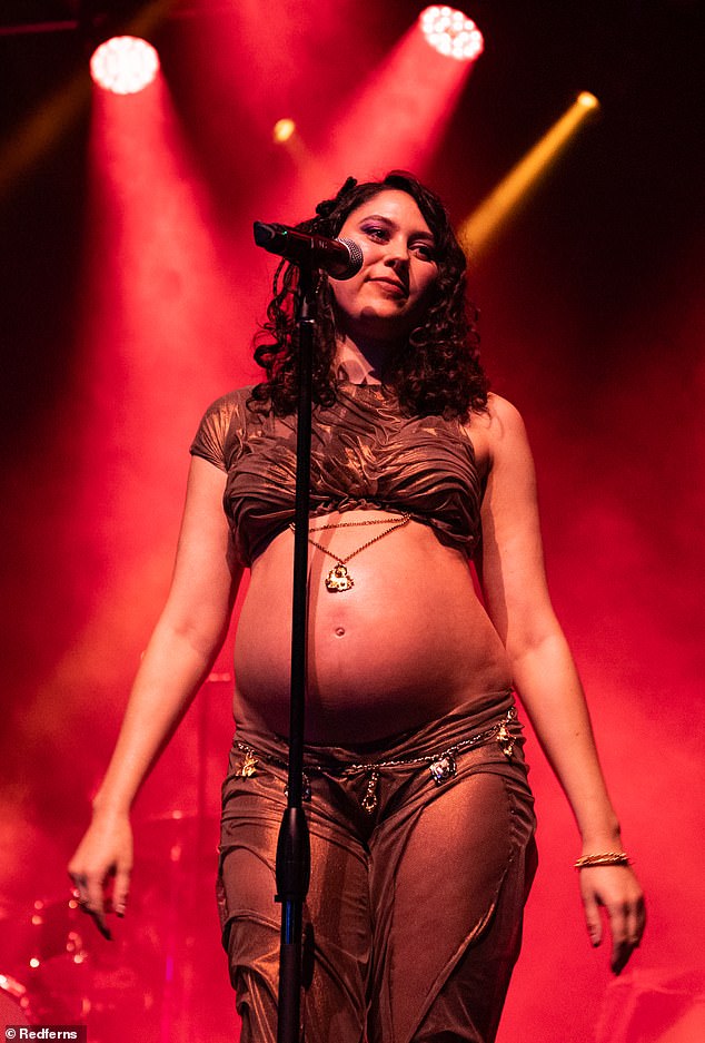 Wearing a sparkly two-piece, Eliza revealed her bare baby bump to the stunned audience in attendance.