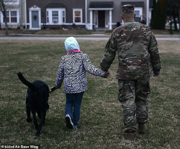 Military families complain about the quality of housing, schools and health care.  Pictured: A military police officer walks with his daughter and dog at Joint Base Langley-Eustis, Virginia.