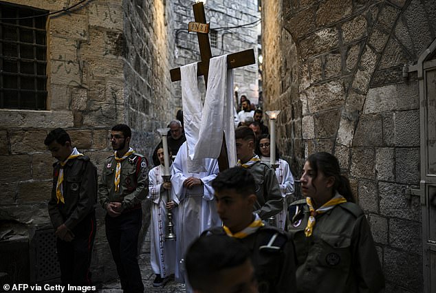 Palestinian Christians take part in the Good Friday procession in the Old City of Jerusalem.  The day's processions, which normally attract thousands of foreign visitors, were unusually local.  Most of the observers were Palestinian Christians.