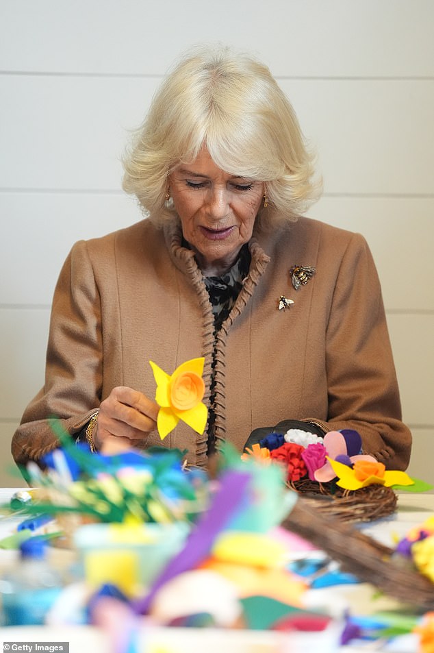 Queen Camilla attempts to make a spring wreath during a visit to Shrewsbury Flaxmill Maltings in Shropshire on March 27, 2024.