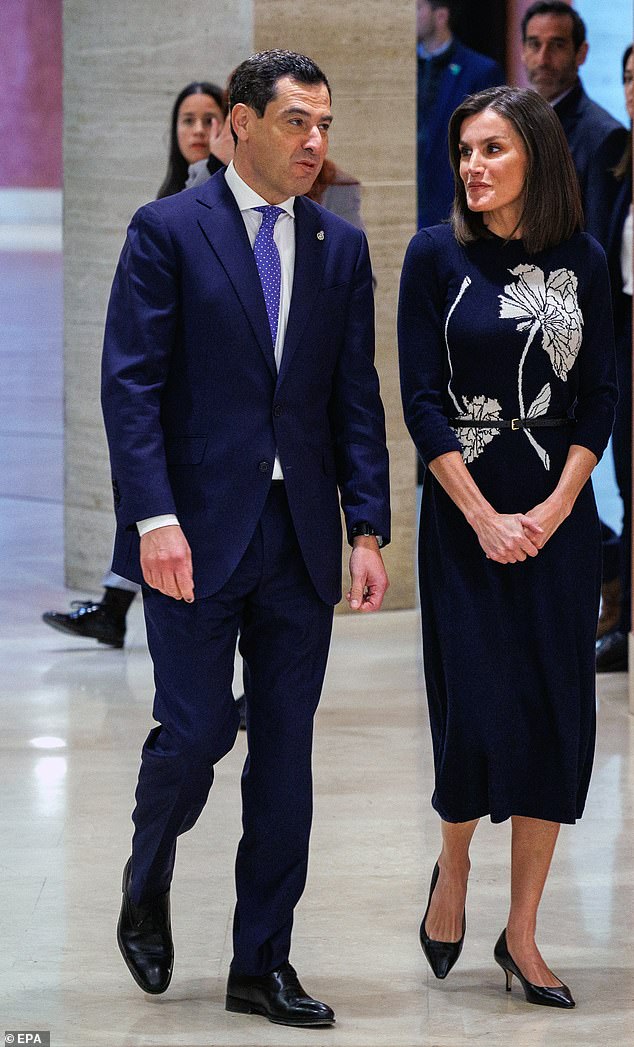 Pictured with Andalusian President Juanma Moreno, Queen Letizia of Spain wore an elegant navy knit midi dress by Spanish designer Galcon Studio when she attended an event to mark World Rare Disease Day in Seville on Tuesday 5 of March.