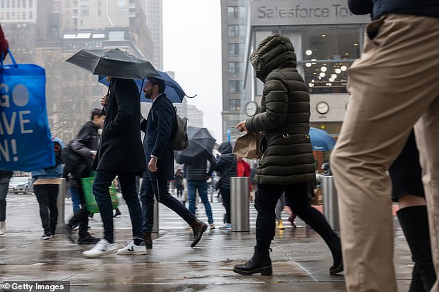Millions of people in the North East are under flood warnings as rain is forecast to hit the region for 24 hours straight.  Pictured: People walking in the rain in New York City
