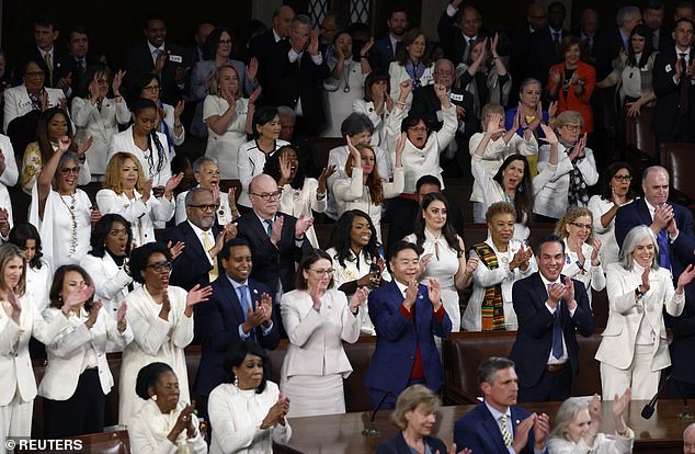 Democratic members of Congress applaud President Joe Biden during State of the Union address; Many Democratic lawmakers wore white to show their support for reproductive rights.