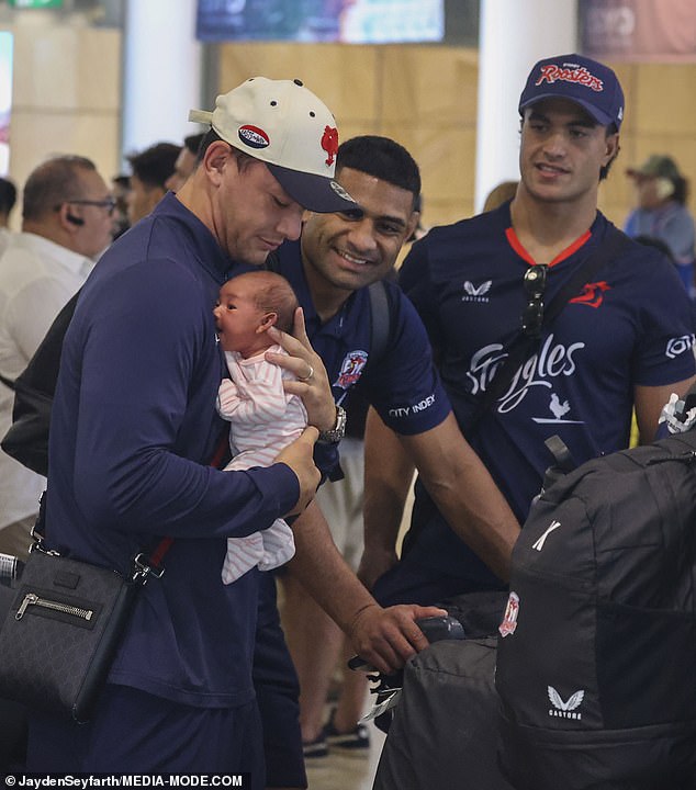 Joey Manu is seen reunited with his newborn daughter at Sydney Airport on Tuesday as teammates Daniel Tupou (centre) and Joseph-Aukuso Sua'ali'i (right) look on