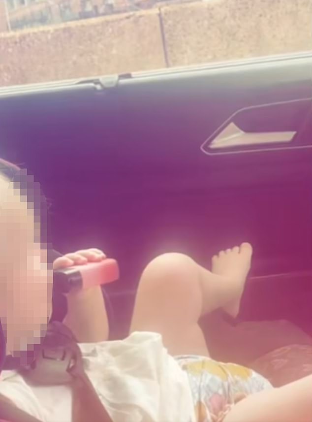This is the moment the young toddler takes a puff of the vapor while sitting in a car seat