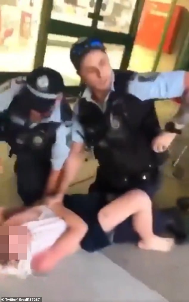 Two police officers are seen restraining the boy after he was caught vaping.