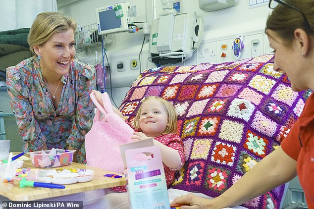 During her engagement, Sophie (pictured, left) was photographed with two-year-old patient Astrid Walker (pictured, center).