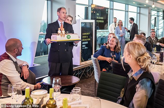 The Duke of Edinburgh looked happy as he carried his gigantic 60th birthday cake.