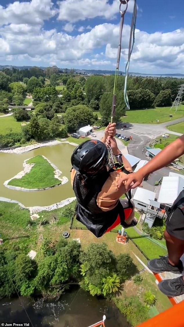 A thrilling clip shows a woman falling a staggering 141 feet from the sky on a new bungee jumping attraction that has NO rope (pictured: woman anxiously waiting to descend)