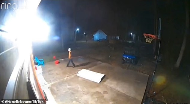 The video shows a man wearing a bright orange jacket walking toward his home in Columbus County, North Carolina, around 1 a.m.