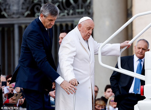 The Pope was helped by an assistant as he attempted to climb into the back of the popemobile.