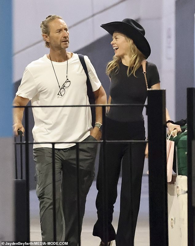 Billionaire bar czar Justin Hemmes' model girlfriend Madeline Holtznagel wore a giant cowboy hat as the couple returned to Australia after a trip to America on Friday