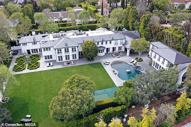 The music mogul's children were photographed handcuffed outside the Holmby Hills residence in Los Angeles (pictured).