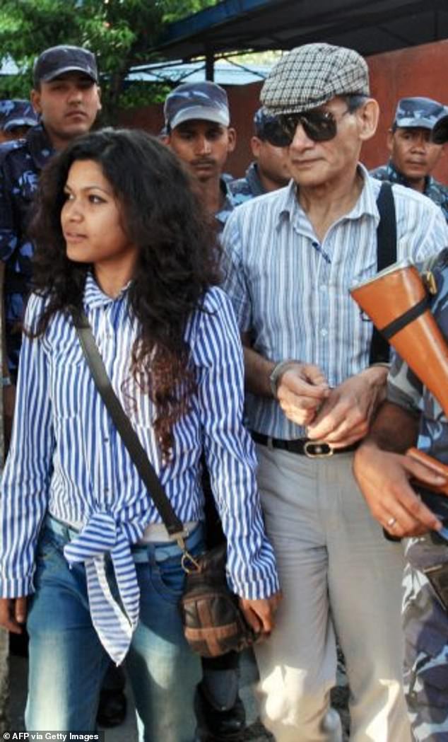 Charles Sobhraj (right) and his wife Nihita Biswas (left) are guided by Nepalese police officers to a waiting vehicle after a court hearing in Kathmandu on May 31, 2011.