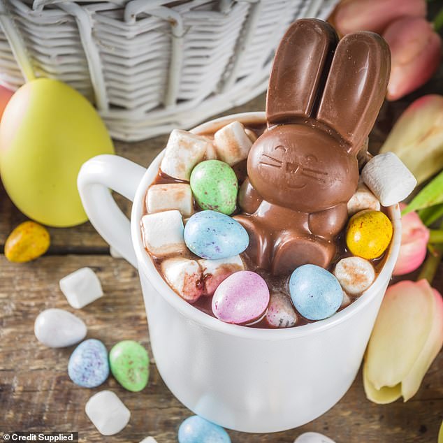 Hot chocolate presented in a white mug, with mini Easter eggs and an Easter bunny for a festive touch.