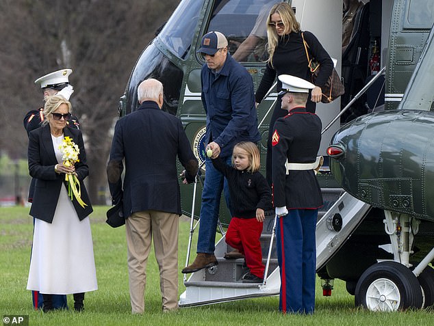 Baby Beau Biden held a small Easter egg in his hands as he stepped off the helicopter and was escorted by his grandparents.