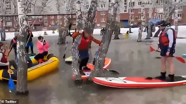 Community members gathered to swim across the icy body of water in their inflatable boats.