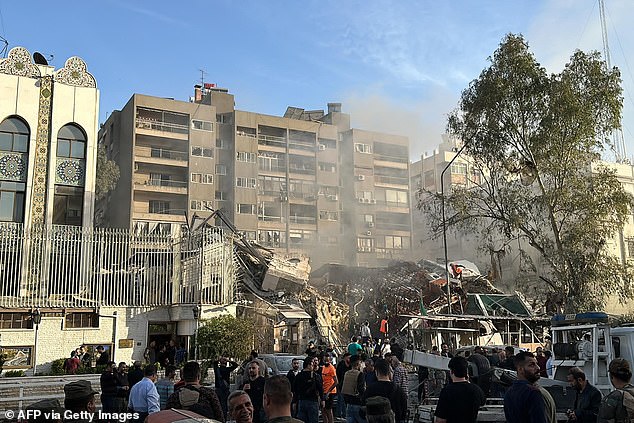 Footage shows the building in Syria's capital razed, with emergency personnel on the scene.