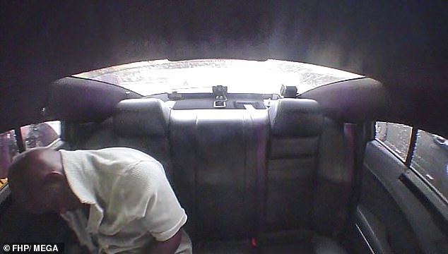 Dashcam footage sees the 34-year-old man sleeping in his seat in the back of a police car.