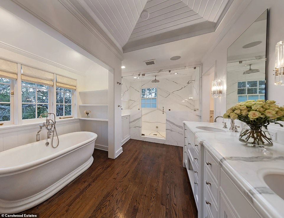 The farmhouse-style bathtub is the main attraction of this well-appointed bathroom with hardwood floors.