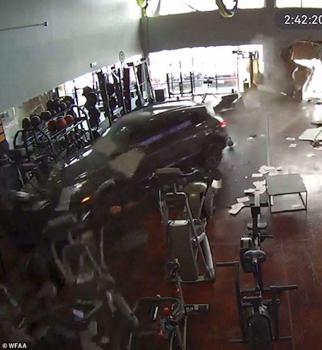 As the car crashed through the gym wall, it took the couch with it, pushing both the seated man and the couch toward a set of elliptical machines and stationary bikes.