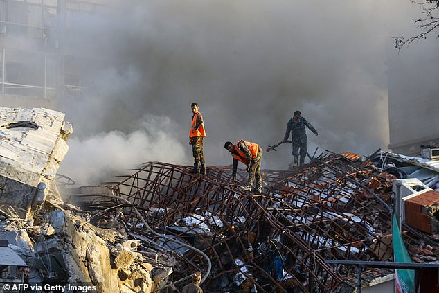 The attack on the Iranian consulate building killed at least seven people, an Iranian ambassador said.  Emergency personnel are seen today extinguishing a fire at the site of the attacks that hit a building next to the Iranian embassy.