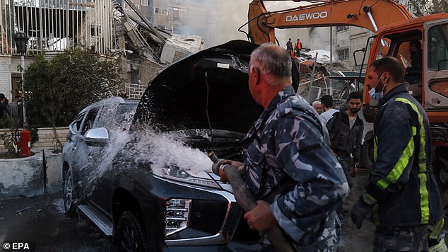 A damaged vehicle is soaked after an airstrike next to the Iranian consulate in Damascus, Syria, Monday, April 1, 2024.