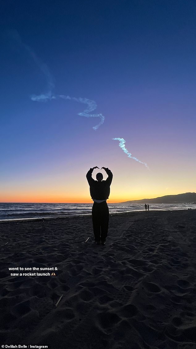Delilah posted an image of herself standing on the beach with her arms extended above her head.