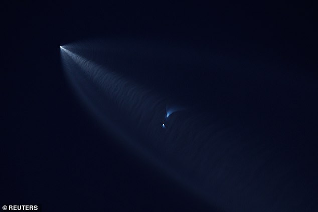 The rocket booster can be seen returning to Earth and is the object in the middle of this photo.