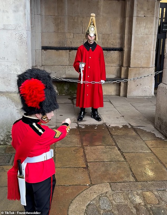 The young man walks towards a large crowd of people who are taking photographs of the guard and patiently waits his turn to greet his double.  Showing his manners, the young man finally reaches the front, but not before letting a woman approach and take a photo with the royal guard.
