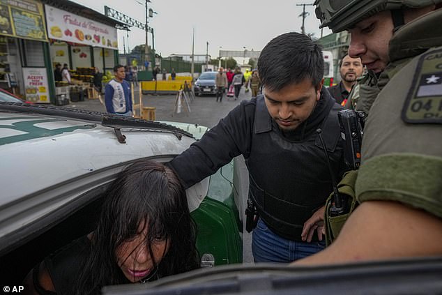 The woman is detained after she grabbed a security guard's gun and fired, wounding three people, outside the Lo Valledor wholesale market in Santiago, Chile, on Monday, April 1.