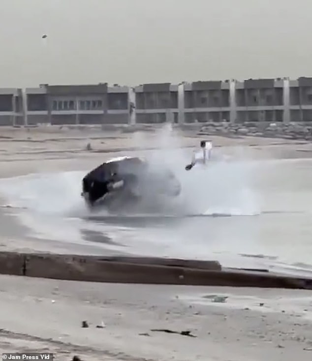 The driver can be seen getting out of his car as it hits the sand and rolls into the water.