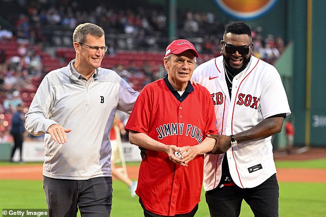The former CEO is pictured with current President Sam Kennedy (L) and former player David Ortiz (R) following a pregame ceremony at Fenway Park in August 2023.
