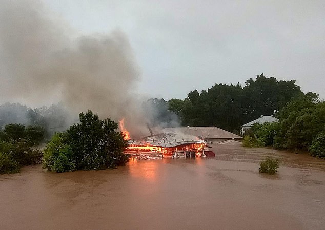 A house in Lismore, northern New South Wales, engulfed in flames while submerged in floodwaters in 2022