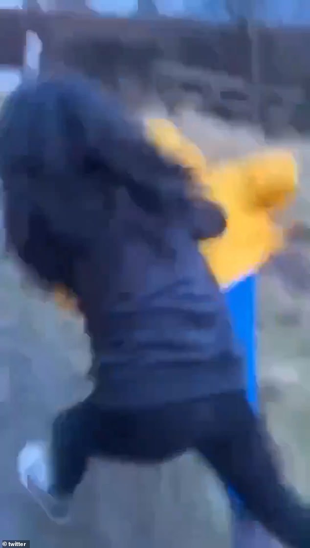 The moment a teenager pushes the woman to the ground where she falls on her face