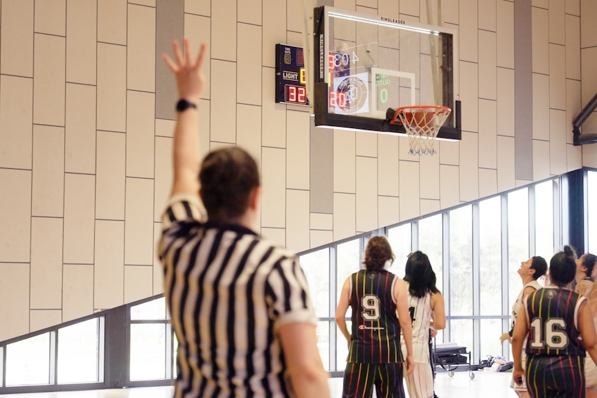 The referee awards a four-point shot in the QSA basketball tournament