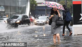 Woman nearly drowns after being swept into a stormwater drain amid wild weather hitting Victoria, with no one able to hear her screams for help over rushing water (file image of wild weather in Melbourne)