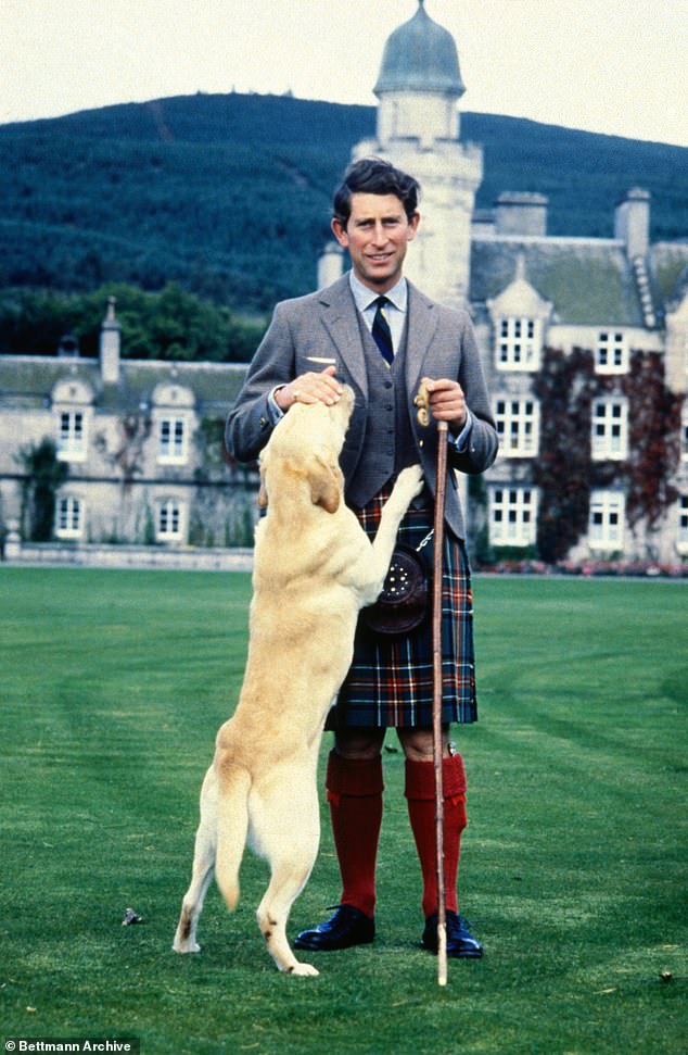 Prince Charles, the then Prince of Wales, pets golden retriever Harvey, during a photo shoot at Balmoral Castle.