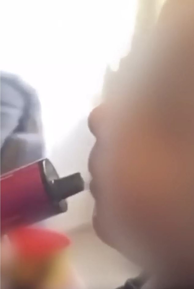 In a series of distressing video clips posted online, the baby, believed to be between one and two years old, is seen inhaling a pink vaporizer (pictured).