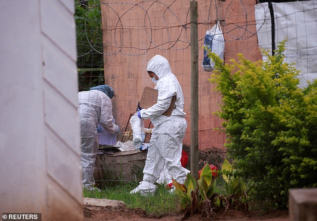 Forensic scientists examine the scene where suspected criminals were killed during a police raid in Marianhill, near Durban.