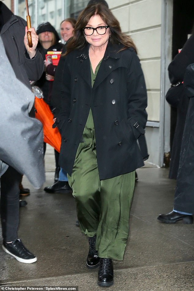 The artist, who recently opened up about going through some of the most difficult years of her life, dressed in a jet black coat double-breasted over a dark green dress.