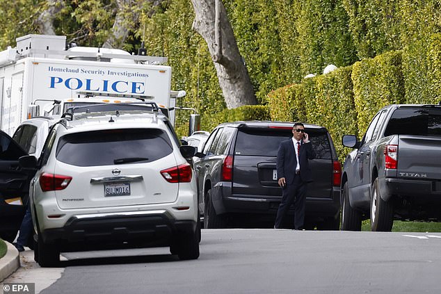 The timing means the singer, 37, may even have been working with the feds in the run-up to the dual Homeland Security raids on the 54-year-old rapper-turned-executive's Los Angeles and Miami mansions; Homeland Security seen outside his home in Los Angeles on March 25