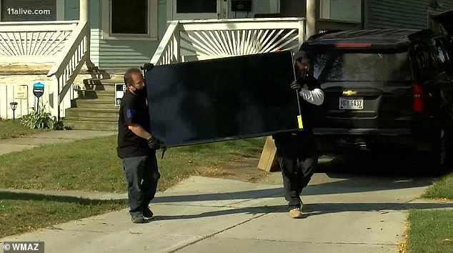 Law enforcement officers photographed removing large furniture from Toledo house
