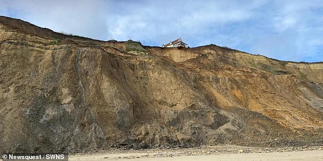 Footage shows how the two coastal homes have been left in a precarious position after cliffs slipped at Trimingham in Norfolk.